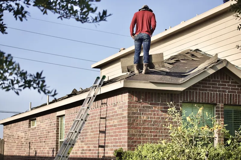 Professional roofer working on a residential roof in Orchard Village